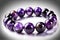 Bracelet made of purple glass beads on a white background.