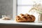 Braided bread with crispy brown crust in light kitchen interior