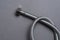 Braided stainless steel water hose over grey background