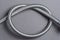 Braided stainless steel water hose over grey background