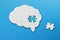 Brain shaped white jigsaw puzzle with copy space on blue background, a missing piece of the brain puzzle, mental health and proble
