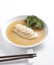 Braised abalone dipped in sauce served in white plate, isolated with white background