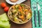 Braised liver with onions, carrots, potatoes and spices on stone plate. Wooden background. Close-up