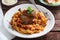 Braised Rabbit Leg in Tomato Sauce with Homemade pasta, dark rustic background