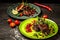 Braised ribs with berry sauce on two plates decorated with seedlings of peas, sunflowers, beets