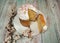 A branch of a blooming apricot and a glazed Easter cake decorated with sugar sprinkles, with a cut slice close-up on a white plate