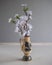 A branch of a blossoming apple in a vase with a pattern. A branch of artificial flowers