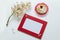 Branch of the blossoming chestnut, red frame for a congratulation inscription, lemon cake on a white background.