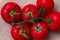 Branch of fleshy tomatoes on a wooden table