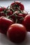 A branch with juicy, ripe, bright red tomatoes lies on a white background, in natural light from the window