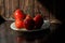 Branch of ripe red tomatoes on brown table in the kitchen. Hard light. Text space