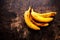 A branch of rotten ripe bananas on vintage wooden background. Overripe banana close up.