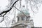 Branch of a tree on a snowy day and detail of the dome of the National Assembly of Serbia in distance