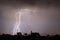 Branched lightning in a slow moving thunderstorm over trees.