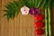 Branches of bamboo and foliage with red pebbles arranged in lifestyle zen and flowers orchids on wooden background