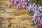 Branches of a blossoming purple lilac, on old wooden table