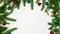 Branches of a Christmas tree border on one side on three sides with red and green balls on a white background