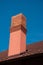 Brand new brick chimney on the roof of a residential house blue sky summer day