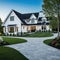 A brand white contemporary farmhouse with a dark shingled roof and black windows is seen in OAK on