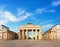 Brandenburg Gate in Berlin, Germany. Panoramic image, symmetrical front shot on a bright day with blue sky and light feather