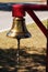 Brass bell hanging from red post