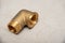 Brass metal fitting on gray cement background, close-up, copy space. Renovation concept