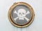 Brass porthole on ship with pirate flag