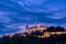 Bratislava castle illuminated in evening glow against dramatic sky