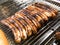 Bratwursts being grilled on an outdoor BBQ grill