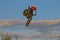 A brave biker jumps very high on a motorcycle and performs a stunt.