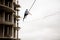 Brave blonde woman walking on a slackline against the grey sky