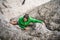 Brave Caucasian girl in a green coat climbing cliffs