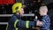 Brave firefighter in uniform hugs a little boy with a toy against a fire engine