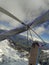 Brave hang glider pilots fly on high altitude over mountain peak covered by snow