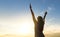 Brave happy young woman raising hands up in the air.