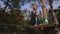 A brave little boy is walking on a rope holding a carabiner in a rope Park.