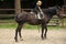 Brave little girl riding a horse. Girl ride on horse on summer day