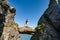 Brave traveler woman standing on hanging stone between rocks. Djevelporten in Norway Lofoten islands