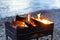 Brazier chargrill, burning firewood, smoke, hot flame of fire on river shore natural background