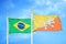 Brazil and Bhutan two flags on flagpoles and blue cloudy sky