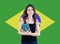 Brazil concept with cute woman student against the Brazilian flag background. Travel in Brazil and learn portuguese language