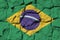 Brazil flag depicted in paint colors on old stone wall closeup. Textured banner on rock wall background