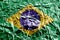 Brazil flag depicted in paint colors on shiny crumpled aluminium foil closeup. Textured banner on rough background