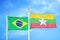 Brazil and Myanmar two flags on flagpoles and blue cloudy sky