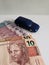 brazilian banknotes and figure of a car in dark blue