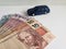 brazilian banknotes and figure of a car in dark blue