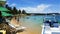 Brazilian beach full of people, umbrellas and boats.