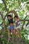 Brazilian children climbing in tropical tree