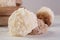 Brazilian cocada coconut candy in close up placed in a wooden pot on a table with white towel, selective focus