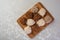 Brazilian cocada coconut candy placed on a polished board on a table with white towel, top view